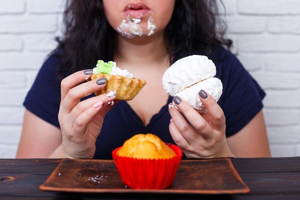 an overweight woman eating sweets